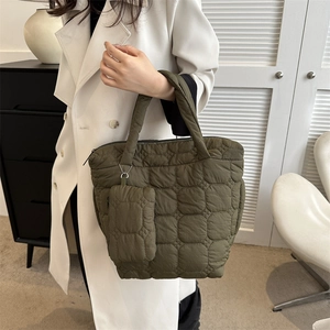Olive green quilted puffer tote bag with matching detachable pouch shown by a model