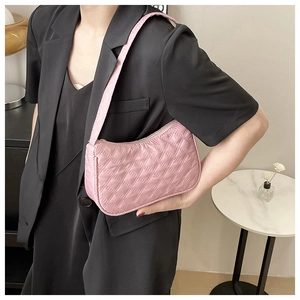 Close-up of pink quilted nylon shoulder bag with elegant stitching and zipper detail