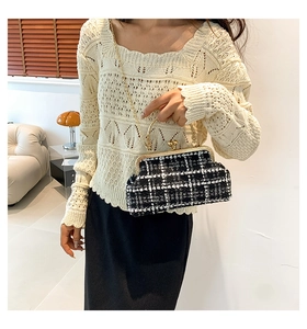 Detail of checkered tweed frame bag with golden chain strap on stylish outfit