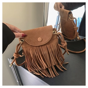 Détails d'un sac à bandoulière en daim marron avec franges et boucles dorées vintage