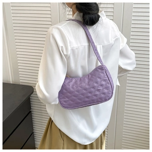 Detail of purple quilted crescent shoulder bag with elegant diamond stitch pattern