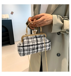 Detail of vintage plaid tweed handbag featuring a gold floral engraved handle and chain strap