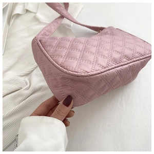 Close-up of pink quilted underarm bag showing detailed stitching and nylon fabric texture
