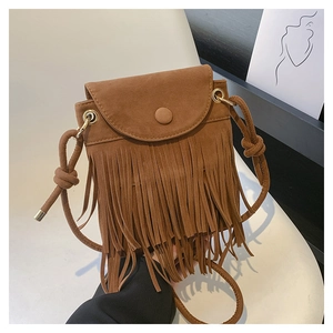 Détail d'un sac bandoulière en daim marron avec de longues franges et boucle ronde