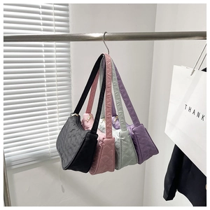 Detail view of quilted rhombic pattern handbags in black pink green and purple colors