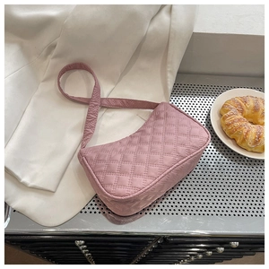 Chic pink quilted rhombic stitching hobo bag displayed on an elegant white blazer