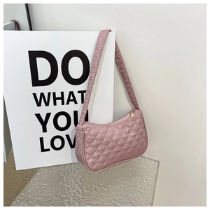 Detailed view of dusty rose quilted shoulder bag with golden zipper and wide strap