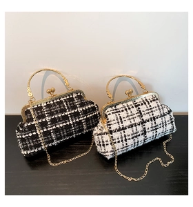 Detail of tweed crossbody bag with golden metal handle and classic clasp closure
