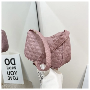 Close-up of pink quilted underarm bag showing the texture of synthetic fiber and stitching
