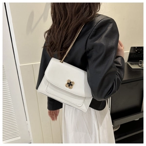 Détail du sac à bandoulière en cuir blanc avec fermoir métallique en forme de trèfle doré