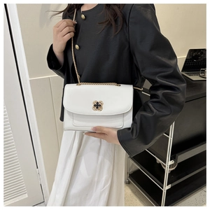 Détail du sac bandoulière blanc en similicuir avec fermoir trèfle doré et chaîne fine