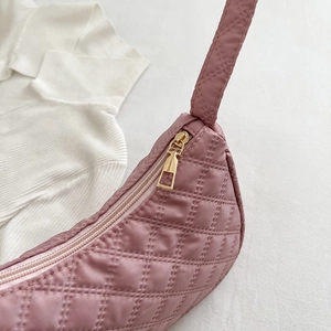 Chic quilted underarm bag in dusty pink with elegant gold zipper and crescent moon shape