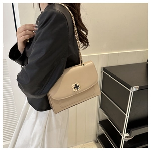 Détail du sac à chaîne en cuir abricot avec fermoir métallique en forme de trèfle doré