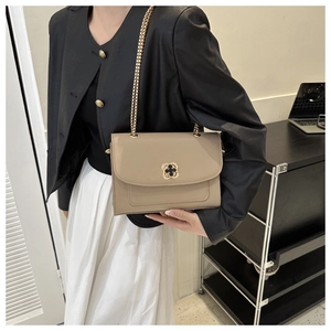 Détail du sac bandoulière carré kaki avec serrure florale dorée et chaîne élégante