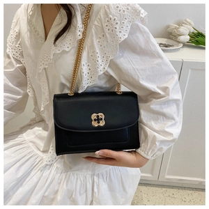 Sac bandoulière carré en cuir noir avec chaîne dorée et fermoir floral élégant