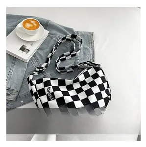 Détail de l'étiquette mode sur le sac bandoulière en toile à damier noir et blanc