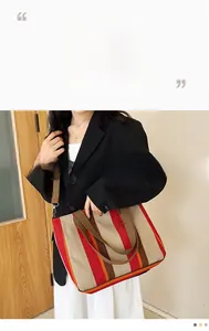 Detail of striped canvas tote bag with adjustable shoulder strap and metal hardware hooks