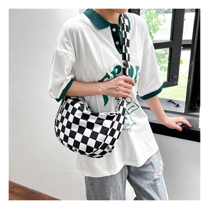 Détail du sac bandoulière à carreaux avec sangle FASHION porté par un mannequin