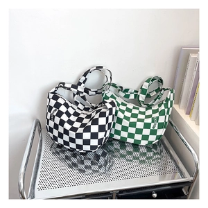 Détail de sacs hobo en toile à carreaux noir et vert avec texte décoratif fashion