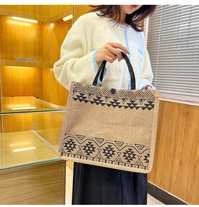 Detail of linen tote bag featuring geometric patterns and black ribbon handles