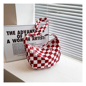 Détail du sac à bandoulière en toile à damier rouge et blanc avec sangle et fermeture éclair