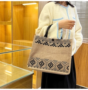Detail view of large jute tote bag with black geometric tribal patterns and sturdy strap