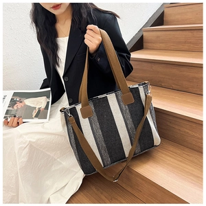 Macro shot of vertical striped fabric texture and brown handles on a large tote bag