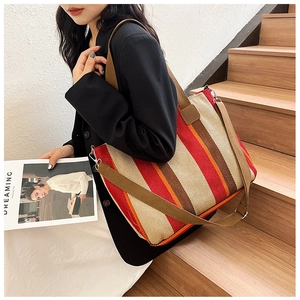 Detail of red and brown striped canvas tote bag with adjustable shoulder strap and metal buckle