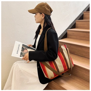 Detailed view of canvas tote bag with warm vertical stripes and detachable strap