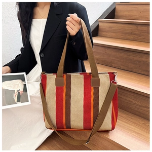 Close-up of a striped woven canvas tote bag with a removable wide adjustable shoulder strap