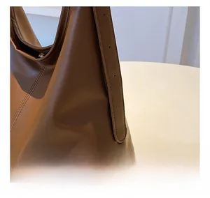 Détail d'un cabas en similicuir marron avec texture litchi et bandoulière réglable