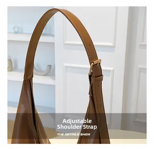 Gros plan sur la bandoulière réglable en cuir marron avec boucle en métal doré