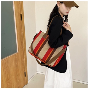 Detail of colorful striped canvas tote bag showing texture and dual shoulder straps