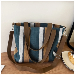 Detail of multi-color striped canvas tote bag with adjustable strap and woven texture