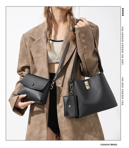 Three-piece black tote bag set with crossbody and pouch featuring gold hardware
