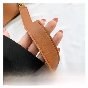 Detailed macro view of the brown leather shoulder strap with reinforced stitching
