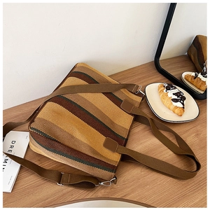 Detail of retro striped canvas tote bag with woven handles on a wooden table setup