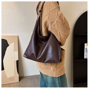 Macro detail of high-quality brown leather tote bag showing soft texture and fine stitching