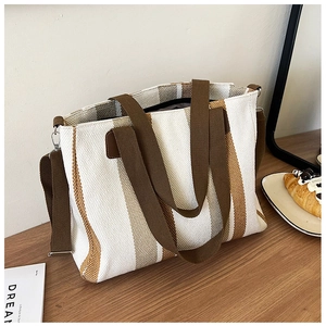 Detailed macro view of the striped canvas tote bag with adjustable brown strap