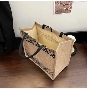 Macro view of large jute tote bag showing geometric print and inner zipper pocket