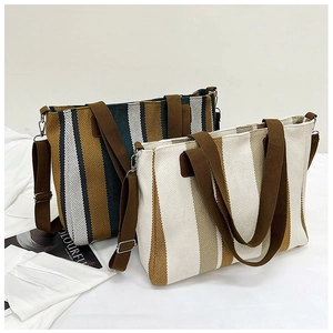 Detailed view of striped canvas tote bags with adjustable brown cotton shoulder straps