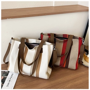 Close-up of striped canvas tote bags showing reinforced handles and textured fabric