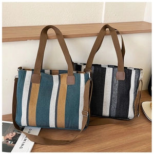 Detail of high-capacity striped canvas tote bags with adjustable shoulder straps and top handles