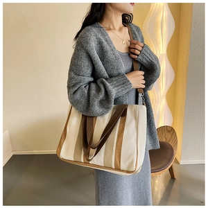 Minimalist large canvas tote bag with brown stripes on a model in a modern room