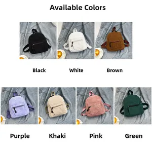 Close-up of small corduroy backpacks in seven colors on denim background with side pockets