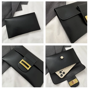 Detail of black envelope clutch showing gold metal hardware and interior phone compartment