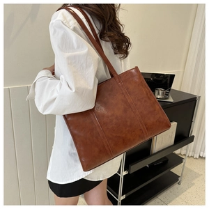 Macro shot of large retro brown oil wax leather tote bag with natural grain texture