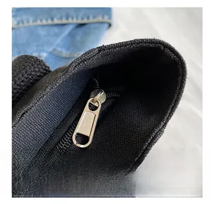 Primer plano de una cremallera metálica suave en un bolso tote de lona negra