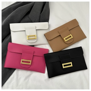 Flat lay of envelope clutch purses in white, brown, pink, and black with gold buckles