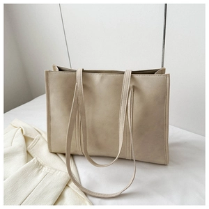 Detail view of beige matte leather tote bag with reinforced stitching and long straps